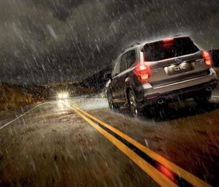 Image of a car driving through rain.